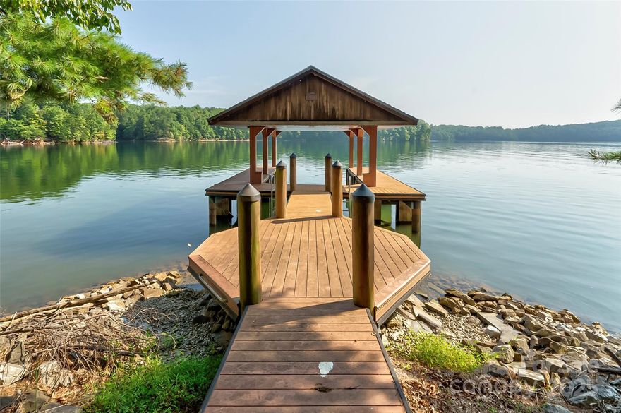 The ultimate in privacy and location on beautiful Lake James.  This 13.8 acre parcel in Black Forest is well prepared for your private or family compound.  Beautiful stone columns greet you at the entrance to the property.  The level drive leads you from the cul de sac through the property, across the stone flanked ravine to the hand built barbeque and rock fire ring near the waters edge. Zero entry stone walkway into the water makes swimming easy for everyone and your pets. Covered stationary dock has a tongue and groove ceiling with pull down steps to a storage area above.  Over 1500+ feet of shoreline with rock stabilization.  Multiple building sites with lake and mountain views.  Gradual slope over most of the property gives room for a main house and multiple guest homes.  Enjoy miles of hiking trails throughout the community which also has a full time caretaker, community building, Open Space meadow, Lake and Riverside Camps for gathering and enjoying nature.