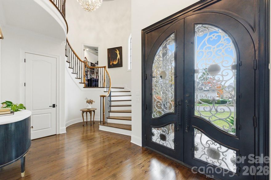 This 5,906 sq ft French Provincial masterpiece on .53 acres blends timeless European architecture with modern living, shown by the full stone and brick construction, architectural turrets with copper roofing, custom Clark Hall French doors, and three-car garage with cedar doors. 
The two-story foyer with grand spiral staircase opens to a soaring great room filled with natural light anchored by rich architectural detail, and floor-to-ceiling brick fireplace. The formal dining room features inlay hardwood flooring and a tray ceiling, offering an elegant setting for gatherings.
The chef’s kitchen is a showpiece of quality and design, centered around an oversized island wrapped in Walker Zanger Taj Mahal quartzite. A full-height backsplash, Brizo pot filler, a full suite of top-tier Wolf appliances, and ample counter space make everyday cooking and large-scale entertaining effortless. Spacious walk-in pantry with custom shelving completes the space, and a charming wet bar with hand-painted tile and beverage refrigerator elevates the flow for hosting.
The main-level primary suite provides a serene retreat with a spa-like bathroom, freestanding tub, separate dual vanities, and custom closets.
Upstairs, a spacious billiards/bonus room with painted wood beams and a full bar becomes an instant gathering space. The billiards table conveys, making the room completely ready for use on day one. There are three additional bedrooms all complete with spacious walk-in closets and ensuite bathrooms ensuring comfort and privacy for family and guests. Finally the flex room which could be used as a playroom, personal gym, sitting nook, or library. 
Outside, the private, fenced backyard offers a peaceful escape with mature landscaping, screened-in porch, a stone patio plumbed for a built-in grill, and a large stone fire pit with seating for many—an ideal setting for year-round outdoor living. Spacious garage with epoxy floor has keyless entry in two locations, Atom Power 11.5kw EV charger, custom shelving with a workbench, sink/faucet, wall organization, and an additional storage area with built-in cabinets to make seasonal storage easy.
Recent improvements include: • 30-year architectural roof (2022) • Mini-split HVAC for bonus room (2021) • Two additional HVAC units (2016) • Navien tankless water heater (2024) • Atom Power 11.5 kW EV charger (2024) • Complete interior improvements in 2022.