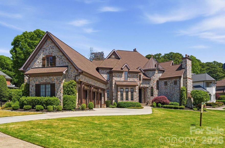 This 5,906 sq ft French Provincial masterpiece on .53 acres blends timeless European architecture with modern living, shown by the full stone and brick construction, architectural turrets with copper roofing, custom Clark Hall French doors, and three-car garage with cedar doors. 
The two-story foyer with grand spiral staircase opens to a soaring great room filled with natural light anchored by rich architectural detail, and floor-to-ceiling brick fireplace. The formal dining room features inlay hardwood flooring and a tray ceiling, offering an elegant setting for gatherings.
The chef’s kitchen is a showpiece of quality and design, centered around an oversized island wrapped in Walker Zanger Taj Mahal quartzite. A full-height backsplash, Brizo pot filler, a full suite of top-tier Wolf appliances, and ample counter space make everyday cooking and large-scale entertaining effortless. Spacious walk-in pantry with custom shelving completes the space, and a charming wet bar with hand-painted tile and beverage refrigerator elevates the flow for hosting.
The main-level primary suite provides a serene retreat with a spa-like bathroom, freestanding tub, separate dual vanities, and custom closets.
Upstairs, a spacious billiards/bonus room with painted wood beams and a full bar becomes an instant gathering space. The billiards table conveys, making the room completely ready for use on day one. There are three additional bedrooms all complete with spacious walk-in closets and ensuite bathrooms ensuring comfort and privacy for family and guests. Finally the flex room which could be used as a playroom, personal gym, sitting nook, or library. 
Outside, the private, fenced backyard offers a peaceful escape with mature landscaping, screened-in porch, a stone patio plumbed for a built-in grill, and a large stone fire pit with seating for many—an ideal setting for year-round outdoor living. Spacious garage with epoxy floor has keyless entry in two locations, Atom Power 11.5kw EV charger, custom shelving with a workbench, sink/faucet, wall organization, and an additional storage area with built-in cabinets to make seasonal storage easy.
Recent improvements include: • 30-year architectural roof (2022) • Mini-split HVAC for bonus room (2021) • Two additional HVAC units (2016) • Navien tankless water heater (2024) • Atom Power 11.5 kW EV charger (2024) • Complete interior improvements in 2022.