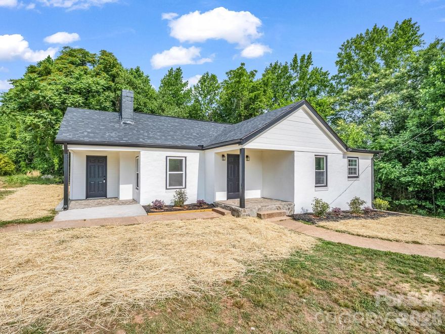 Circa 1948 cottage style home thoroughly renovated inside & out and popping with visual charm.  A fresh coat of stucco plus new vinyl windows pair with a dark shingle roof & black gutters to perfectly compliment the stone porches.  The main entryway opens to a spacious living area with the u-shaped kitchen/dining area to your right.  All new richly colored cabinetry, stainless appliances and quartz countertops with a wall-mount chimney hood for a fantastic focal point.  Primary bedroom just off the kitchen w/convenient built-in shelving in the bath.  Shared hall bath offers a full shower and double bowl vanity.  Huge laundry room w/separate entrance and ample space to add your own customized drop zone.  Luxury vinyl plank and recessed lighting throughout.  Public utilities, access to high speed internet and all improvements permitted and inspected.  If you're looking for a home you can move into without worrying about needed updates or deferred maintenance issues, DON'T MISS this solid property priced RIGHT!