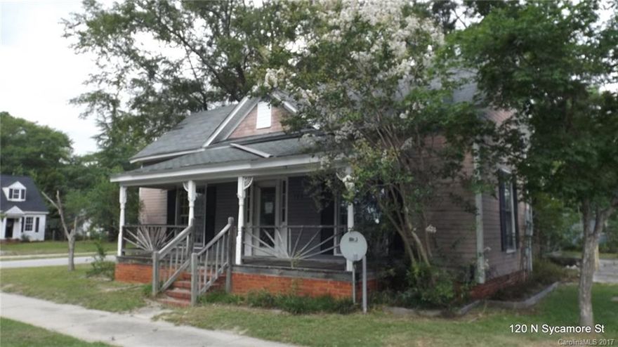 History home with gingerbread accents and rocking chair front porch. Located in the heart of downtown Pageland, this home features a modern kitchen plan and attached rear carport.  Ready for your updates and renovation project plans.  Two storage building and level corner lot.  Small town living at it's best.  Call before it's gone!