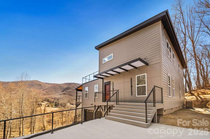 This 2,958 sq ft contemporary home sits on a private 1.06-acre lot and features 4 bedrooms and 3 full bathrooms, along with a 2-car, 699 sq ft garage. This stunning modern two-story home offers a bright, open layout designed for comfort and style, with beautiful mountain views. The main floor features a spacious living area, kitchen, laundry room, and two bedrooms, while the upper level includes two additional bedrooms, including a primary suite with a private bath and access to a large sun deck — perfect for enjoying the scenic mountain views. Additional highlights include two covered porches and over 650 sq ft of outdoor deck space ideal for entertaining or relaxing. Located in a quiet and safe community, just 5 minutes to I-40 and 20 minutes to West Asheville.