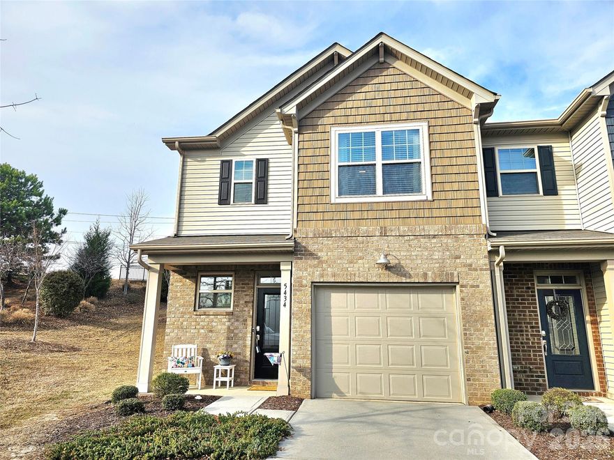 Welcome home to this stunning townhome in sought-after Indian Land, SC — one of the Charlotte metro's most desirable and fastest-growing areas, offering suburban tranquility with convenient access to uptown Charlotte, top-rated Lancaster County schools, and premier shopping and dining along the Ballantyne and Fort Mill corridors.

Enjoy increased privacy with this beautiful end-unit home, and it's partially fenced rear patio space. 

This beautifully maintained townhome impresses with its classic brick exterior and attached one-car garage. The finished, drywalled garage provides secure parking plus additional storage — a rare bonus in townhome living.
The open-concept main level seamlessly connects living, dining, and kitchen areas, ideal for everyday living and entertaining. Rich hardwood-style flooring flows throughout, lending warmth and elegance underfoot.

The chef-inspired kitchen is an absolute showstopper. Crisp white raised-panel cabinetry stretches to the ceiling, while stainless steel appliances — including a gas range, built-in microwave, and French door refrigerator with ice and water dispenser — elevate form and function. The dramatic curved peninsula features an undermount sink, generous counter space, and casual seating. A large walk-in pantry and bold steel-blue accent walls complete this unforgettable space.

Upstairs, the grand primary suite is a true sanctuary. A dramatic tray ceiling with crisp white trim, plush neutral carpet, and a ceiling fan create a space that feels both luxurious and comfortable. The suite offers direct access to a private en suite bath with soaking tub, plus a spacious walk-in closet with built-in shelving and a secondary closet for additional storage.

Indian Land's Lancaster County location means lower property taxes while remaining minutes from I-485, I-77, and all the amenities of the Queen City. This move-in ready gem is perfect for first-time buyers, professionals seeking low-maintenance living, or savvy investors. Schedule your private showing today — this one won't last!
