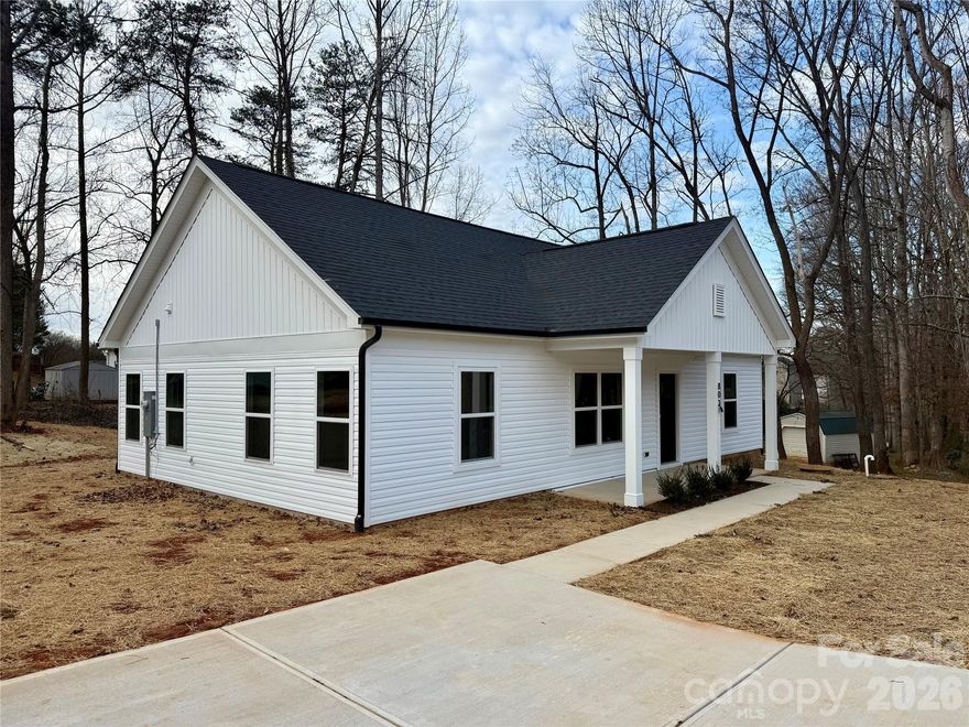 For sale—new construction home in the Court Street Commons neighborhood in Newton, NC!
This beautifully finished 3-bedroom, 2-bath home offers a desirable split-bedroom layout with an open floor plan that makes the main living area both comfortable and functional.
The kitchen is a standout, featuring white shaker-style cabinetry, granite countertops, a large center island with bar seating,  perfect for prep or casual dining, stainless steel appliances, and a classic subway tile backsplash. Pendant lighting and recessed lights brighten the space, while the window over the sink brings in natural light. The flooring adds warmth and contrast.
Connected to city water and sewer, this home is conveniently located near shopping, dining, and major roads for easy commuting—combining quality construction with everyday convenience.