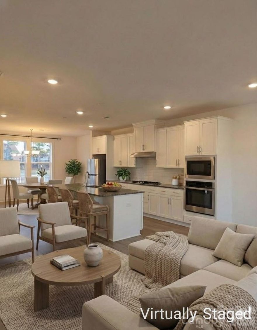 REDUCED PRICE!! Beautifully designed, desirable Christenbury Greene townhome with over 2,200 square feet is an end unit that backs to natural space and  is located at a dead-end st for maximum privacy and minimum drive by traffic. Main level large bedroom has two walk-in closets, a private en-suite full bath, French door leading to covered patio and rear yard area. Upper level has dramatic open floor plan with huge kitchen featuring quartz countertops and a 10' sit-down island for entertaining and maximum prep surface. Gourmet gas range, walk-in pantry, and tons of cabinets make up this cook's dream kitchen. Dining room area opens to the extended length, private balcony/deck overlooking private rear yard.  Great room features wall of windows creating beautiful light-filled living space. Spacious primary bedroom boasts 2 walk-in closets, a trey ceiling, en-suite full bath with large, tiled walk-in shower w/seat. Two additional bedrooms, full bath and laundry also located on the third level. Conveniently located extremely close to shopping, dining opportunities and easy access to I-85 and I-485