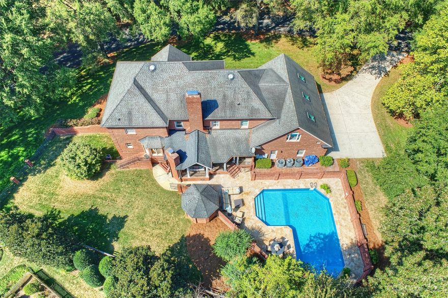 NEW ROOF COMING SOON!!! Situated in the tree-lined Quail View neighborhood on a lush, landscaped lot, this palatial home offers a serene lifestyle just minutes away from SouthPark and Ballantyne.  The stately brick home boasts classic craftsmanship with crown molding, chair railing, and detailed brickwork.  Spacious and light-filled living areas with a formal dining room for elegant entertaining. Expansive primary bedroom with ensuite bathroom and attached flex space. Five additional bedrooms, including a main-level bedroom and a four-room second living quarters in the walkout basement. Luxurious outdoor living space for entertaining, with outdoor cooking area, fireplace with gas starter, and generous sized porch overlooking a large saltwater pool.  Massive bonus room over three-car garage. Over 40 new double paned, windows were installed on 10/23/23. Don't miss the rare opportunity to own a timeless beauty in this highly sought-after neighborhood. *Notable comp: 4201 Quail Hunt.