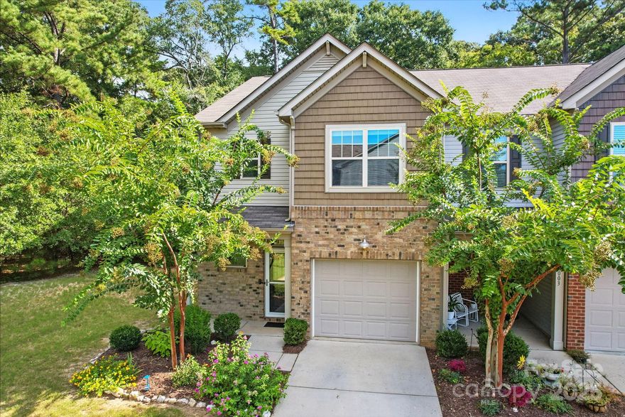 Beautiful end-unit townhome. Light-filled and move-in ready, it features 3 bedrooms, 2.5 baths, and a bright open layout with wood floors on the main level. The kitchen shines with granite countertops, stainless appliances, and tall cabinets, opening to a spacious great room that leads to a private patio framed by peaceful wooded views where birds and deer often wander. Upstairs, the primary suite offers a garden tub, separate shower, and walk-in closet, with two additional bedrooms and a full bath nearby. Enjoy details like 2-inch blinds, a paver patio, and a raised garden bed. Perfectly tucked in the back of the community for extra privacy, yet just minutes from shopping, dining, and top schools.