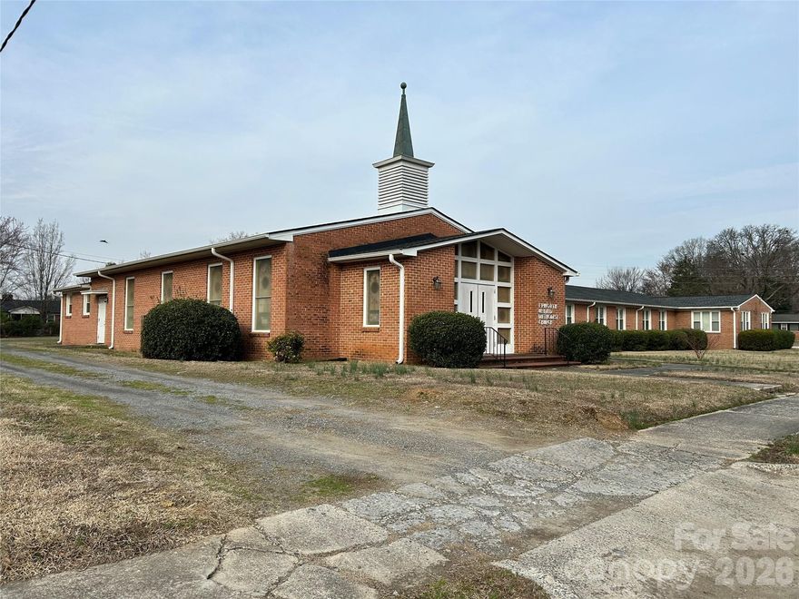 Located in the heart of Rock Hill, the Epworth United Methodist Church campus offers a unique opportunity on approximately 1.5 acres with three well-maintained buildings and recent major updates throughout. The main church building features a beautiful sanctuary adorned with stained glass windows, six Sunday school classrooms, a pastor’s study, secretary’s office, boiler room, and four restrooms. The second building includes a spacious social hall, fully equipped kitchen, seven additional Sunday school rooms, three bathrooms, and its own boiler room—ideal for fellowship gatherings, events, and community programs. A detached two-car garage provides additional storage space and flexibility. Recent improvements include a new roof on all three buildings, recent heating and air conditioning systems, and all furnishings will remain, making this a truly turnkey opportunity for continued ministry or redevelopment. With ample space, functional layout, and a peaceful setting, this property is ready to serve its next chapter. Built in approximately 1966, the property contains almost 15,000 square feet under roof.