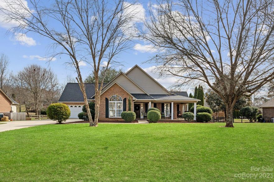 Lovely 3bd/2ba brick home sitting on nearly 1/2 acre offering plenty of room to make it your own! The living room features vaulted ceilings & a gas log fireplace, while the large kitchen with granite countertops & ample storage overlooks an enclosed sunroom on the back of the home. The dining room is adorned with bay windows & accommodates large gatherings. The primary suite boasts a walk-in closet & full bath with shower & soaking tub. The 2 secondary bedrooms also offer walk-in closets. The extended driveway leads to both an attached 2-car garage & a detached 2-car garage that features a finished flex space on the 2nd floor. The fenced backyard & patio are perfect for grilling & entertaining. Relax on the large, wraparound front porch overlooking a peaceful road, which connects to a quiet loop ideal for walks, biking, etc. Recent upgrades include a newer roof, HVAC, water heater, & dishwasher. Access to shopping, restaurants, schools, medical offices, & a public park with boat ramp.