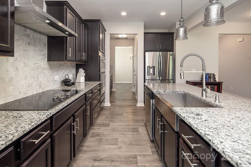 Welcome to Tillery Tradition! This beautiful 2019-built 2-story Wakefield model by TruHomes offers 5 bedrooms, a bonus/game room, and 3.5 baths. The main level features a spacious primary suite, office, mudroom, dining room, and a kitchen with granite countertops, a large island with farm sink, stainless steel appliances, and a butler’s pantry. The open living room includes a wood-burning fireplace. The primary bath offers a soaking tub, updated tile shower with dual heads, and dual vanities. Upstairs boasts 4 bedrooms, an awesome bonus room, and a Jack-and-Jill bath. Sitting on one of the largest lots in the community, this home backs to the golf course! Offering $1,500 buyer concessions! Assumable mortgage is available at 5.99% interest rate!