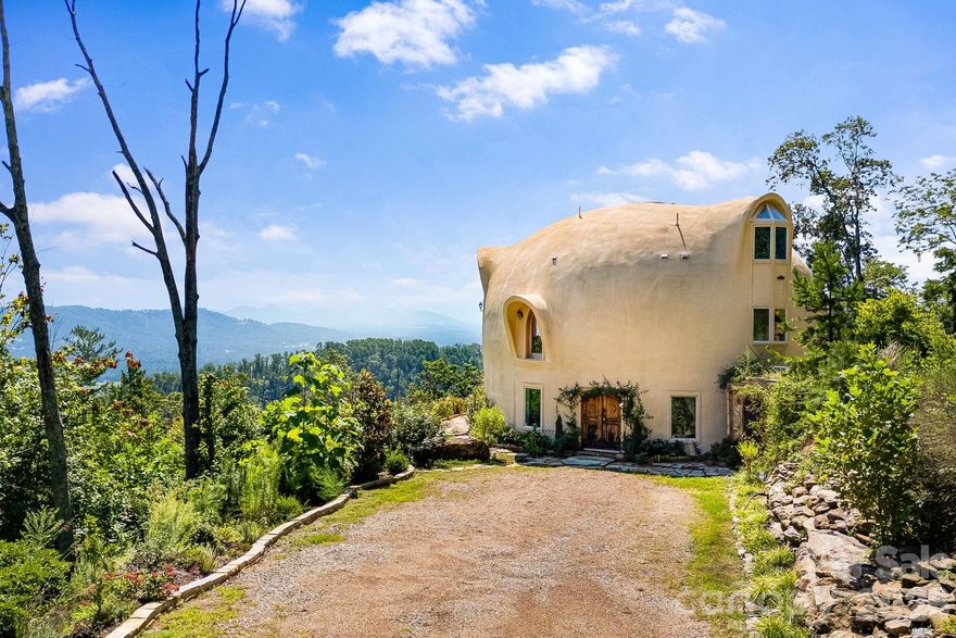 Welcome to Azura Gardens. A rare Mountain Sanctuary with a Dome Home & Guest Cottages.  

  Perched above the clouds, this extraordinary mountain estate offers a rare blend of breathtaking panoramic views, timeless design, and exceptional privacy- while being 10 minutes from Weaverville and 17 minutes from downtown Asheville. From sunrise to sunset, the sweeping horizons create a backdrop of ever-changing beauty, while the roughly 28 acres of land itself provides both abundance and tranquility. This is more than a property- it's a lifestyle of creativity, peace, and connection.

  At the heart of the estate stands a remarkable ~3,400sf Dome Home, a handcrafted monolithic structure designed with energy efficiency and artistry in mind. With two bedrooms, two and a half baths, and both a full kitchen and kitchenette, the home balances comfort with sustainability. Interior features include custom woodwork, arched details, and a built-in observation beehive. Spa-like bathrooms showcase custom tubs and a steam shower, while a wood stove in the living room provides cozy off-grid heating. Exceptional insulation with an R-value of 84 ensures year-round comfort. Every detail of this unique residence reflects vision, intention, and craftsmanship.

  Complementing the Dome Home are two exquisite guest cottages, each designed as a retreat of their own. The Stone House (approx. 295 sq. ft.) shows elegance with a Moroccan aesthetic, featuring stucco walls, stone cabinetry, artisan finishes, and an open-plan layout with a walk-in shower. The Creek House (approx. 295 sq. ft.) offers serene living at the water’s edge, inspired by Japanese Wabi-Sabi design. With stucco interiors, stone cabinetry, a walk-in shower, and a patio overlooking the spring-fed creek, it is a peaceful hideaway connected to nature by a winding stone path.

  The roughly 28 acres of land surrounding the residences is equally extraordinary. A year-round creek meanders through the property, while private wells and multiple natural springs provide pure, abundant water. The grounds are alive with beauty and self-sufficiency: vibrant pollinator gardens and an apiary support bees and butterflies, a rose garden adds cultivated charm, and fruit trees are scattered throughout the landscape. With ample space for additional building sites, the property offers flexibility for expansion while preserving its sense of seclusion. Trails and roadbeds wind across the terrain, inviting exploration by foot, bike, or horseback, and providing endless opportunities for outdoor adventure.

  Each element of this sanctuary has been created with care and intention, resulting in a property that is both functional and inspirational. Whether you are looking for a private mountain retreat, a sustainable homestead, or a profitable venue for hosting and gathering, it offers a rare opportunity to own such a unique piece of property- ready for its next owner to continue to add and make it their own.

  Interactive map link: https://id.land/maps/9960b013da816c6381914f40593e84e7/share/unbranded