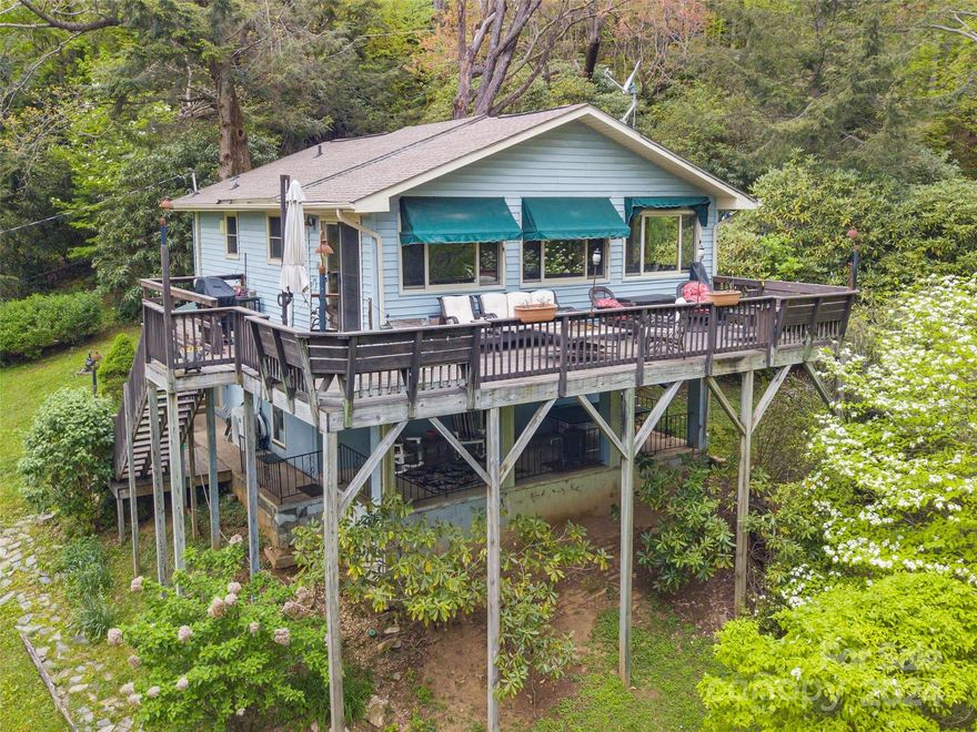 Uncover the magic of mountain living in Walker-In-The-Hills with this two-bed, two-bath home, offering a perfect setting for a short-term rental or your private retreat! Sunlight dances through large windows, highlighting the built-in bookcases in the dining area and the inviting fireplace. This captivating cabin bungalow boasts year-round mountain panoramas from its airy living space with wood cathedral ceiling with accent beams. Indulge in the sun-drenched primary suite on the main level, while a spiral staircase descends to the second guest suite with its private entrance, offering seamless comfort. The kitchen radiates tasteful white cabinetry, an island, a built-in desk, and tile floors. Step out onto the deck, where the landscape's beauty invites you to entertain or unwind amidst nature's splendor. Modern luxuries abound, including replacement windows, Spectrum for seamless connectivity, and an Ultraviolet Water System ensuring pristine water quality.