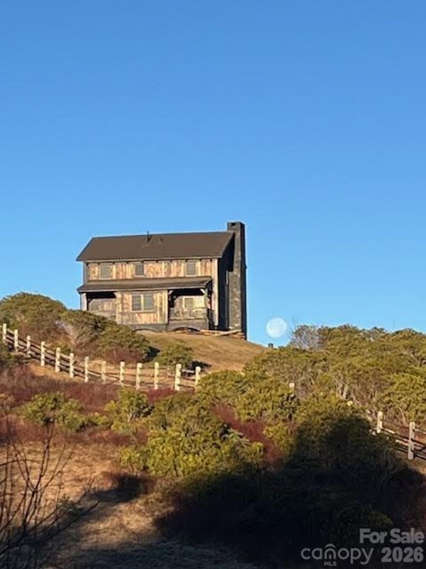 Looking for a mountain home that feels worlds away yet is built to stand the test of time? This handcrafted log retreat offers just that. Perched on a windswept bald a mile above sea level, it’s rare to find a home available at this elevation with such enduring craftsmanship. Enjoy breathtaking views of Mount Mitchell, the Smokies, and Pisgah National Forest—every window frames a postcard-worthy scene. Built in 2007 with 8-inch oak logs, hand-hewn details, and a red cedar exterior topped with a Gerard stone-coated steel roof, this home is made to last. Inside, Carlisle wide-plank walnut flooring, custom walnut doors, and a library with built-in bookcases and a secret door showcase the quality throughout. Located on 1,000 acres of gated wilderness, the property offers complete privacy and 360° mountain views. It’s not suburbia—it’s a place to unplug, recharge, and embrace the beauty of nature.