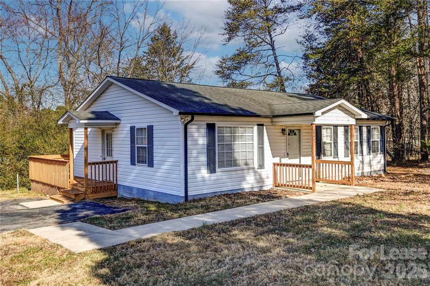 This beautifully updated 2-bedroom, 2-bathroom home blends country-chic charm with modern upgrades and a bright, open-concept layout filled with natural light. The interior has been freshly painted and features new LVP flooring throughout, creating a clean, cohesive feel. Both full bathrooms have been upgraded with brand-new vanities, and the primary suite includes a walk-in shower for added comfort and convenience. The kitchen showcases new appliances and fixtures, highlighted by stylish steel blue cabinetry that adds a warm, modern farmhouse touch. Additional updates include new lighting and window blinds throughout the home. Step outside to enjoy the private wrap-around back deck with built-in bench seating, perfect for relaxing or entertaining while enjoying the peaceful setting. Conveniently located with an easy drive to local schools, shopping, and everyday amenities. One dog is conditional upon owner approval, and no aggressive breeds are allowed. Lawn maintenance included. Anyone age 18+ who would live in the home must complete an application. $75 application fee.