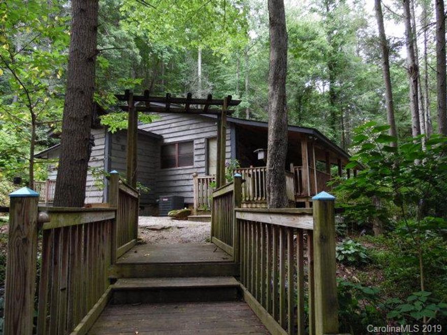MOTIVATED SELLER....CABIN in the WOODS!  Listen to Buck Creek from your covered front porch or enjoy the flowing creek atop the covered deck on your property.  Minutes to  Mt. Mitchell Golf Course and Carolina Hemlock. This property features a potting shed, several chicken coops for your own fresh eggs and a 16 x 24 workshop.   Natural landscaping abode with hostas, ferns, hydrangeas, azaleas and rhododendrons and more.  A stair archway leads to a level area for additional parking or a great place for your outside fire pit. A peaceful and quite get-a-way. Back of property adjoins US Forest Service. Call for your viewing today! Below prior appraised value.