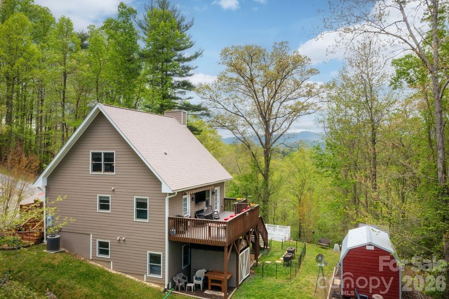Charming mountain retreat 20 minutes from downtown Asheville, nestled on 4.66 beautiful acres. This adorable 3-bedroom, 2-bath cabin offers the perfect blend of privacy, comfort, and breathtaking mountain views. Enjoy peaceful mornings on the porch overlooking mountain views and evenings surrounded by nature. The spacious acreage provides room to garden, explore, or simply relax and take in the fresh mountain air. Conveniently located just a short drive to local amenities, dining, and shopping, this property offers the best of both worlds—seclusion without sacrificing accessibility. The main level features an open floor plan, a primary bedroom with an ensuite bath, and a vaulted-ceiling living room with a wood-burning stove. Upper-level loft features a large guest bedroom with a tongue-and-groove ceiling. The lower level includes another guest bedroom with an ensuite bathroom, a family room, and a gas fireplace. Exterior garden space and 2 large studio workshops wired with electricity, insulated with a loft for all your hobby needs. Whether you're searching for a cozy vacation getaway, a short-term rental opportunity, or a full-time homestead, this sweet mountain cabin is ready to welcome you home. This property is located in Buncombe County, Marshall. The proposed new Publix in Leicester is just a 10-mile drive. The property would make a great STR with most of the furniture included. Don't miss this rare opportunity to own your own slice of paradise!. Peace, privacy, and panoramic beauty await—all just a scenic drive from quaint Marshall and Asheville.