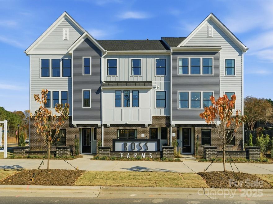 This three-story Bloom plan is the larger of the two designs available at Ross Farms and offers low-maintenance living in the heart of Ballantyne, with convenient access to top-rated schools, shopping, and everyday amenities. From the moment you enter, oak box stairs with metal vertical balusters and a stained stair handrail create a light and welcoming first impression, while a convenient drop zone near the garage entrance helps keep daily routines organized. The first floor also features a fourth bedroom with a full bath, offering flexibility for guests or a quiet work-from-home retreat. The second level becomes the natural gathering place, where a gourmet kitchen with warm brown cabinetry and an upgraded built-in pantry anchors the space. A GE® 36" Built-In Gas Cooktop with dishwasher-safe grates adds both performance and style, while the kitchen flows seamlessly to a covered outdoor living area through a 12-foot-wide sliding glass door, creating an inviting setting for entertaining or relaxed evenings at home. Upstairs, the primary suite is elevated with tiled shower walls and a tiled shower pan, complemented by a secondary bath with tiled walls above the tub.