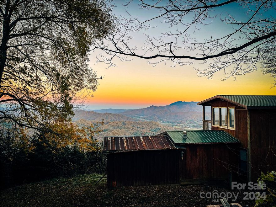 Arguably the best view anywhere in Western NC! These 50 +/- acres have a eastern slope giving way to a view spanning over 4 counties making for breathtaking sunrises. The original structure was built in the 80s as just a place to get away. The two story addition was built in 2000 and the middle connecting the two was constructed in 05-06. While the home has no power, there is a generator to power the lights and also the pump for the water system. Water is collected from a spring in a reservoir and pumped to a smaller holding tank above the home creating a gravity fed system. There can be no "drive-bys." There are two locked gates and the road up is currently ATV only. Must be accompanied by a Real Estate Agent.