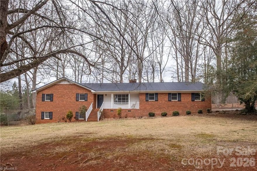 Classic charm meets peaceful country living in this timeless brick ranch nestled on 3+ WOODED ACRES. Surrounded by towering trees and picturesque farmland, this rural estate offers the perfect blend of privacy, tranquility, and possibility. The covered front porch, private balcony, and back patio provide the perfect setting to enjoy quiet mornings, breathtaking sunsets, and sweeping views of your beautiful property. Inside you’ll find spacious living areas accentuated by massive picture windows, exposed wood beams, and 3 wood-burning fireplaces that create warmth and character throughout the home. The 1,578 square foot full unfinished basement offers abundant storage, workshop space, and potential to expand. For those looking to invest or develop, the 3.02 acre lot could potentially be subdivided into 3 additional building lots, creating an exceptional opportunity for future development or multi-generational living. This phenomenal opportunity will not last long, so schedule your private showing today!