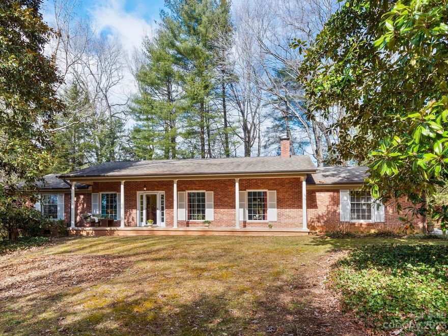Beautiful brick ranch w/ 3 bedrooms & 2 baths on a level 0.84-acre yard. Enjoy the outdoors from the large covered front porch where huge magnolia trees & a row of hemlocks create privacy from street. Inside, you'll love the spacious living room featuring a gorgeous stone-style wall w/ gas fireplace. The kitchen is a chef's delight w/ remarkable space, built-ins, extensive countertops, 2 sinks, & a fantastic functional kitchen island harboring a gas oven range. Picture window in dining room offers view of deer, wild turkeys, foxes, & white squirrels in the back woods. The large sunroom touts surrounding views of the forested backyard framing easy-to-maintain yard space w/ fire pit. Primary bedroom suite & guest rooms are spacious & well-kept. Highlights include fully encapsulated crawl space, extra storage space in attached garage & shed that could make a great studio! Great central location 10 min to downtown Hendersonville, 15 min to Arden, 20 min to Asheville, 25 min to Brevard.