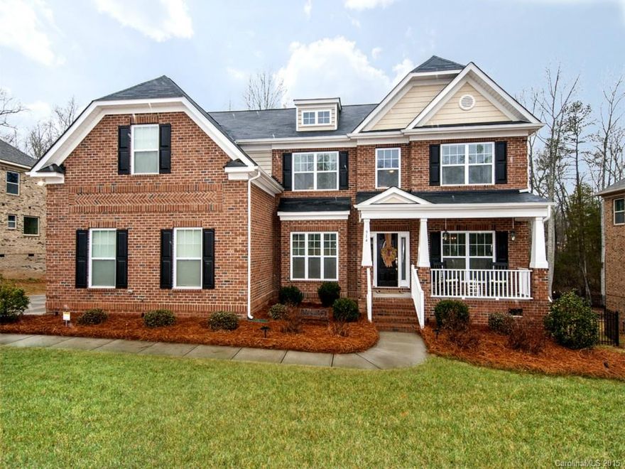 Full brick beauty with 3 car garage and welcoming front porch. Wide Plank, hand scraped hardwood floors throughout the first floor. Gourmet kitchen with gas stove, granite, and 42" castled cabinetry. Great room has gorgeous coffered ceiling. First floor guest suite. The large master suite has a 5-piece bathroom with granite counter tops and ceramic tile. The largest walk-in closet you will ever see. 5 full bedrooms and a bonus room. Tankless water heater. Private, tree lined back yard.