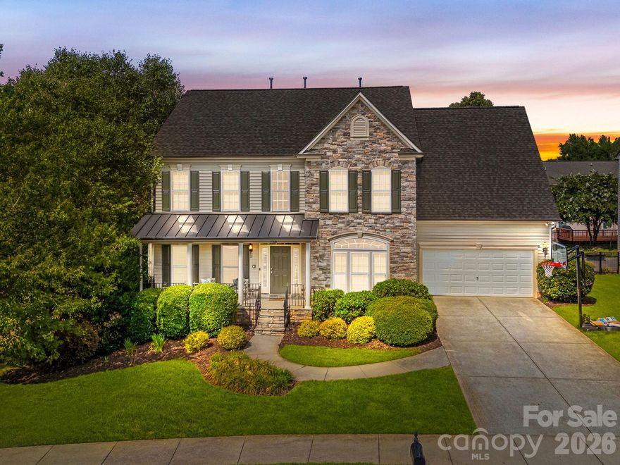 A warm and welcoming beautiful FORMER MODEL HOME that is spacious and full of special features and updates.  This home stands out with all the bells and whistles!  A spectacular chef’s kitchen is complete with Stainless Steel appliances: gas cooktop, double wall ovens, microwave, dishwasher. An abundance of cabinetry and an oversized island with seating. A walk in PANTRY.  The Great Room features a COFFERED CEILING and a lovely gas-log Fireplace with  stone surround and wood mantle. The Main level also features a Private OFFICE/STUDY with French doors, formal dining room and a formal living room, a sunny morning room/ casual dining room, 1/2 Bath, and a Butler’s Pantry.  Well cared for Pristine Wood Floors, NEW Carpet 2025 and Paint, enjoy Surround Sound and extra finishes. UPSTAIRS: Luxury Primary Suite features a sitting area w/columns and a spa-like bath complete with large soaking tub, oversized shower, dual vanities, and dual closets. Nice Crown moldings, as well as a TRAY CEILING and Vaulted Ceilings. The Additional Bedrooms are spacious and include a GUEST En-Suite with a bath. A Large Bonus Room (optional 5th bedroom) and convenient laundry room completes the upstairs. Situated on a corner lot with established landscaping for privacy. **Enjoy the beautiful outdoor spaces: A big Front Porch, DOUBLE DECKS for plenty of room to entertain , as well as a PAVER PATIO to complete the space with built-in BENCHES and FIRE PIT ! **Architectural Roof ( New 2022), HVAC (2017, Trane), and a huge 616 sq ft finished insulated OVERSIZED GARAGE (built to be a 3 car garage). Resort-style amenities around the corner including a large pool, clubhouse, fitness room, playground, and walking trails. The Hector Henry GREENWAY is in the neighborhood. Patriots Elementary within the community, and easy access to Charlotte, I-485, and I-85. Luxury, lifestyle, and location—welcome home!
