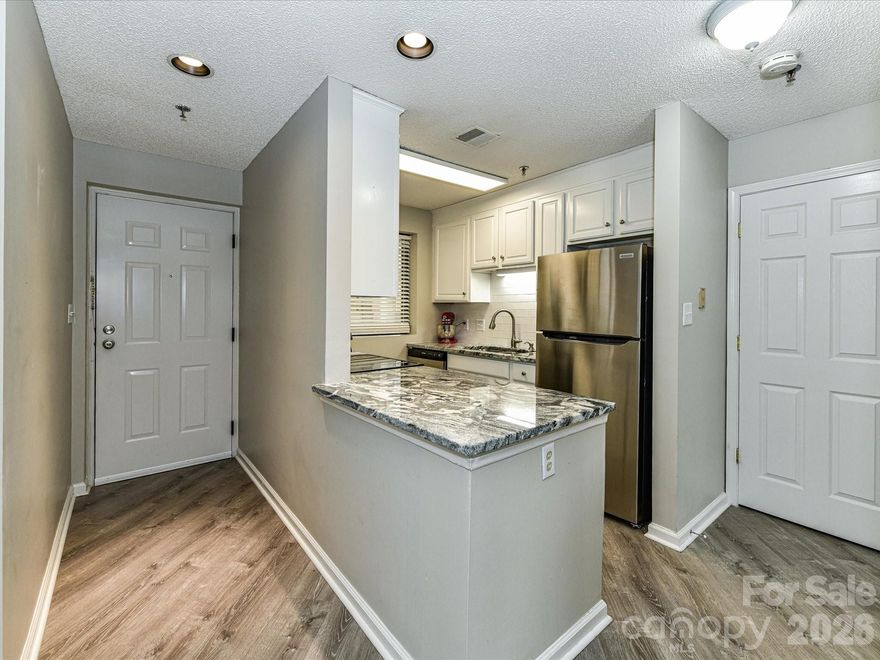 Welcome home to this bright and beautifully maintained 2-bedroom, 2-bath corner unit in the highly sought-after Fort Mill School District. The corner location provides abundant natural light, enhancing the LVP flooring throughout and the open, inviting feel of the home. The kitchen shines with granite countertops, crisp white cabinetry, and stainless steel appliances, perfect for everyday living. The spacious primary suite features an en suite bath with double sinks, ample storage, and a walk-in shower, offering a private retreat. A split-bedroom floor plan ensures added privacy, with a generously sized guest bedroom and full bath that conveniently includes a stackable washer and dryer. Ideally located just minutes from the state line, this home offers an easy commute into Charlotte while enjoying the benefits of Fort Mill living. Comfort, convenience, and location come together in this move-in-ready condo.