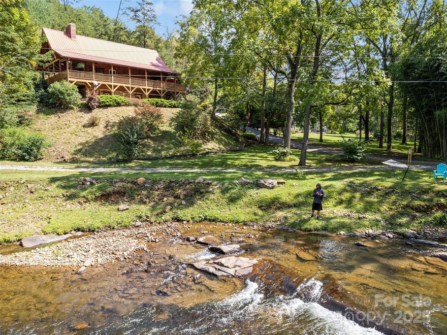 RARE & EXTRAORDINARY creek-front, custom log cabin! This incredible, show-stopping home sits on an exclusive stretch of the trout-stocked Caney Fork Creek! Beyond the vaulted ceilings, warm wood interior, timber stairs, and stone fireplaces, the true gem lies just outside - a stretch of water reknown for trophy trout fishing. Welcoming details such as hickory cabinets, red oak floors, pine tongue & groove walls, and quartz countertops are just a few of the custom aspects of the property. The generous primary bedroom, with its own private bathroom, is on the main level, the upstairs room is expanded into a finished space over the garage, and the basement provides more living areas to use as you desire, such as media, storage, or an office. (Septic recently expanded to 3 bdrm.) After spending time at the creek, unwind by the outdoor, stone fireplace for s'mores and story-telling. Take advantage of the close proximity to Cashiers/Highlands, WCU, Sylva, & Harrah's Casino. This thoughtful, lovingly cared-for home, whether enjoyed as a personal angler's paradise or an escape to nature, gives you a one-of-a-kind retreat to make life-long memories at this unmatched, mountain river setting!
