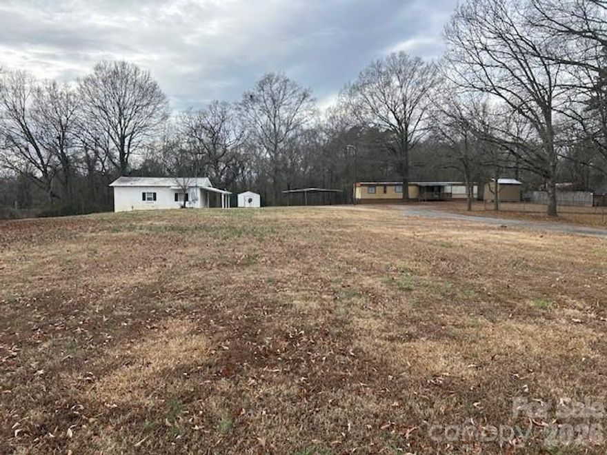 This 1.43 acre lot in the city limits of Marshville has a concrete block one bedroom, one bath, living room, kitchen and dining combination. Interior is in excellent shape and has been used as a rental for several years. There is a covered front porch plus a deck on the side.  Heat and air is a window unit that supplies both. The 1979 single wide mobile home still has the axels and the hitch/tongue still attached and is considered personal property. No title and
"no value" given to mobile home. The mobile home and concrete block dwelling have a water meter. Per Town of Marshville, a lot may could be sold at the road frontage but if survey shows any dwelling/building does not meet the setbacks, approval will be contingent on the block dwelling, building and trailer having to be moved to meet new guidelines. Contact agent for the info from Marshville planning.