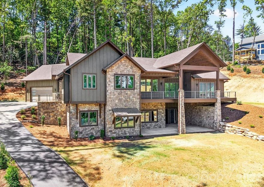 Perched on over an acre of beautifully landscaped Blue Ridge mountain land in the exclusive Northview neighborhood, this NEW mountain-modern masterpiece blends dramatic architecture with refined livability. Thoughtful design maximizes natural light and views with soaring ceiling heights, expansive windows, and premium finishes throughout.

From the moment you arrive, the cut stone exterior entrance and flagstone porch create a striking first impression, complemented by durable LP Smart siding engineered for anti-fade, anti-mold and anti-microbial performance. Built with 2x6 framing, spray foam insulation, a poured concrete foundation reinforced with rebar, an extensive drainage and waterproofing system, 2 HVAC systems, On-demand natural gas water heater, Anderson casement windows, and a whole house Generator, this home was constructed for longevity and peace of mind.
Inside, 10 foot ceilings and 8 foot solid wood doors create an airy, upscale ambiance.  The 3/4 inch solid white oak flooring flows beautifully throughout the main living areas, accented by substantial three piece base molding and custom soft close dovetail cabinetry.

The open, chef’s kitchen is equipped for culinary personalities: quartzite countertops, a spacious island, huge walk-in pantry, 48 inch natural gas range, and premium THOR stainless appliances that flow into generous living and dining areas — perfect for entertaining or relaxed mountain living. Three bedrooms and 2.5 baths on the main level provide single-floor convenience, with a total of five bedrooms and 3.5 baths across the home. 

The Primary suite is a retreat highlighted by a private Trex deck, dual custom finished walk-in closets, linen closet, separate toilet room, Spa inspired bath with Bahia marble and a huge shower with dual shower heads and a waterfall feature.

The heated walkout basement expands your living space with 12 foot ceilings, a special living are with TV box, wet bar with sink and mini-fridge plus a dedicated wine/safe room.

Outdoor living is extraordinary: over 1,500 square feet of Trex decking and concrete patios feature sleek stainless cable railings and multiple entertaining zones. Ample storage on both the main and lower levels keeps the interior uncluttered, while rich exterior stonework anchors the home in its natural setting.

Ideally located between Hendersonville and Asheville, this residence offers privacy, winter mountain vistas, and immediate access to the region’s dining, arts, and outdoor recreation — a modern sanctuary for those who seek luxury and authenticity in equal measure.

Location is less than 12 minutes to Asheville Regional Airport, breweries, grocery stores, world class healthcare, Mills River Park, and Interstate 26,
