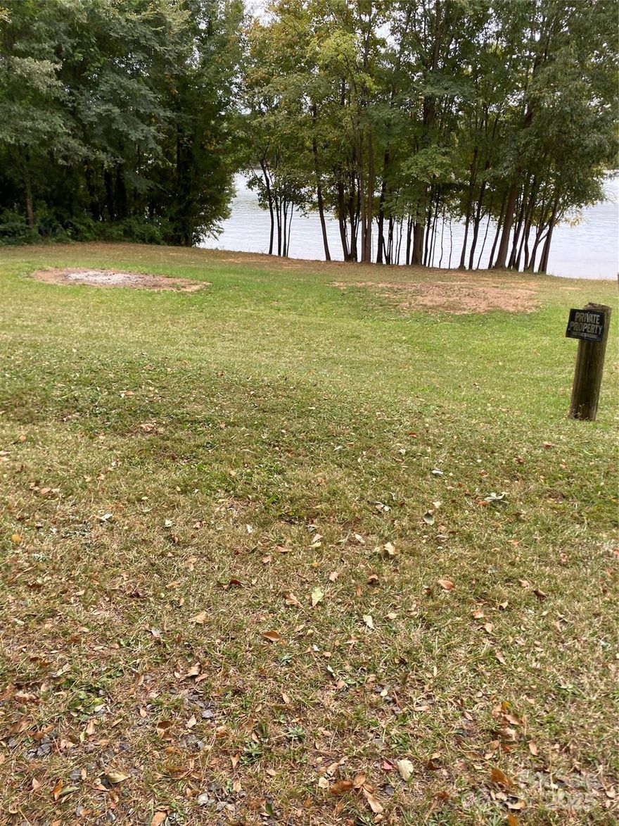 This waterfront lot is located on beautiful Mountain Island Lake. The lot has 105 foot frontage on the lake that allows for a dock to be put in with Gaston County approval. A survey has been included in the attachments to verify this information. There is a small easement that runs across the property which allows a road to one home 2 lots away from this property. This would not impede the quietness and tranquility that this lot would allow. See survey in the attachments. The small home two lots over sold for over $600,000 in 2025. This is a matter of public record. This property will sell itself. Please take a look at it and see.  There is a home on this property that the seller is treating as a teardown due to condition. It is occupied so have agent make appointment for showing.