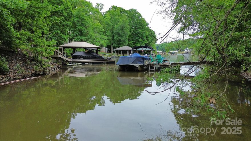 Build your dream home on this peaceful .67-acre creek front lot on Lake Norman. Located in Lincoln County on #5 Woodhill Cove Road, this lot offers paddle sport access and city water and sewer at the road. About 30% of the lot is cleared, ready for your custom single-family home over 1,800 sq ft. Enjoy calm waters and wooded privacy. With generous dimensions and a quiet setting, it's perfect for relaxing mornings or lake adventures. Don’t miss this rare chance for lake access living with room to grow.