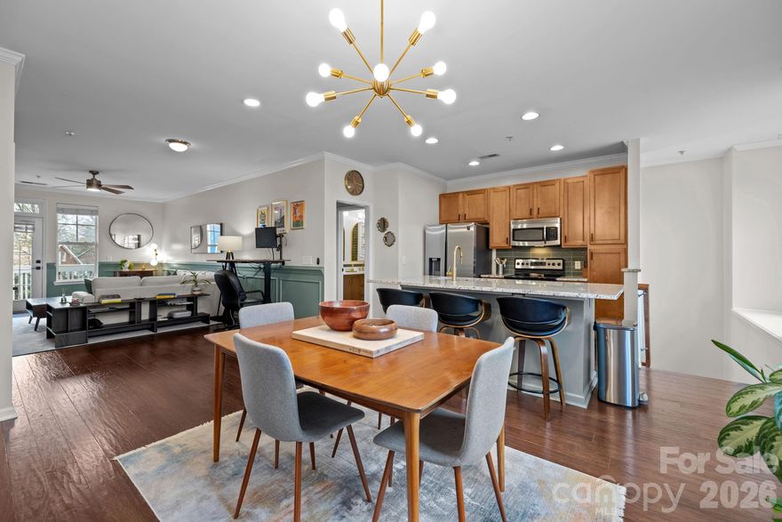 This Weekend Only! Offering $1,000 closing cost credit for any buyer who attends Saturday’s open house from 12:00pm to 2:00pm or schedules a showing and submits an offer by Wednesday at midnight!

Ideally located just minutes from the energy of Uptown, this modern 2 bedroom/2 bath condo combines a prime location with thoughtful, high-end upgrades throughout. Enjoy evenings out on your covered balcony — perfect for morning coffee or evening unwinding — while being just blocks from dining, entertainment and nightlife. Inside, the open-concept layout is designed for both everyday living and effortless entertaining, seamlessly connecting the kitchen, dining and living areas. Designer enhancements elevate the space, including wood flooring, updated lighting and ceiling fans, upgraded hardware, wainscoting in the living room and a beautifully remodeled main level bathroom featuring a dual-sink vanity and a striking tiled walk-in shower with a waterfall shower head. The spacious primary suite serves as a private retreat with a custom accent wall and a closet outfitted with custom built-ins to maximize storage. A generously sized secondary bedroom and full bath are located on the lower level offering privacy and flexibility for guests, a home office or an additional living space (murphy bed included and a separate entrance if you want to use this space as a rental for income!). The indoor HVAC unit was replaced in 2025, and the outdoor has a manufacture date of Feb 2021, offering you peace of mind upon move-in. A spacious attached garage and unbeatable proximity complete this exceptional opportunity for stylish city living!