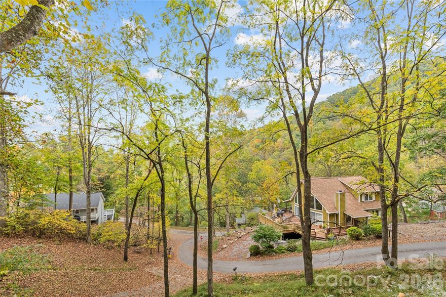 Charming 2BR/2.5BA + BONUS Room Home in Maggie Valley Country Club Estates! This 1998-built mountain home offers comfort, convenience, and great potential! Featuring 2 bedrooms, 2.5 bathrooms, and a versatile BONUS room. Enjoy the full-length covered porch that wraps around the front and side. A large, level paved driveway provides plenty of parking for multiple vehicles. Step inside to the main level with natural light, engineered oak flooring, and a cozy gas log fireplace. The living, dining, kitchen, and laundry areas are all located on the main level for convenience, along with a half bath and the primary bedroom featuring a double-vanity ensuite bath. Upstairs, you'll find a second bedroom, a full bathroom, and a generous BONUS room with a closet. Partial fencing in the back and side yard. The carpet in the bedrooms and stairs is in poor condition. Located just 1.2 miles from the Maggie Valley Club (membership not included), enjoy access to golf, dining, fitness center, pool, and tennis with a membership. Only 7 miles to downtown Waynesville and close to many other area attractions. Short Term Rentals Allowed. Spectrum High Speed Internet. No City Taxes. $100/Yr HOA for Roads.