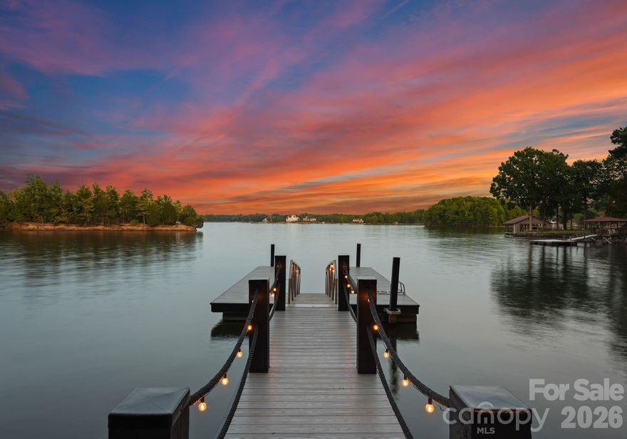 Waterfront living just beyond The Point on Lake Norman! This beautifully crafted home is tucked off the main channel near a charming island, offering calm water, sweeping sunrise views, and incredible long-range sunrise views. Enjoy your own private pier, rare sandy beach, and plenty of space to add a pool and spa.
Designed for comfortable main-level living and optimizing the views, the open-concept floor plan is filled with natural light.  Expansive sliding glass doors open to a large lakeside terrace, creating seamless indoor-outdoor flow — perfect for entertaining or relaxing while taking in the views.
Upstairs features spacious guest suites, while the fully finished lake level includes a movie room, wine cellar, and flexible space ideal for a home gym, office, or additional living area. This home exudes quality construction and architectural design and is a must see.
Outdoor living is a standout with three expansive terraces, a newly constructed dock with composite decking, and a low-maintenance Zen-style front garden. A detached two-car garage with storage above adds extra flexibility.
Located near The Point, with optional access to world-class amenities including championship golf, tennis, pickleball, dining, and more.
Septic permit is for 3 bedrooms; home offers potential for a 4-bedroom configuration.