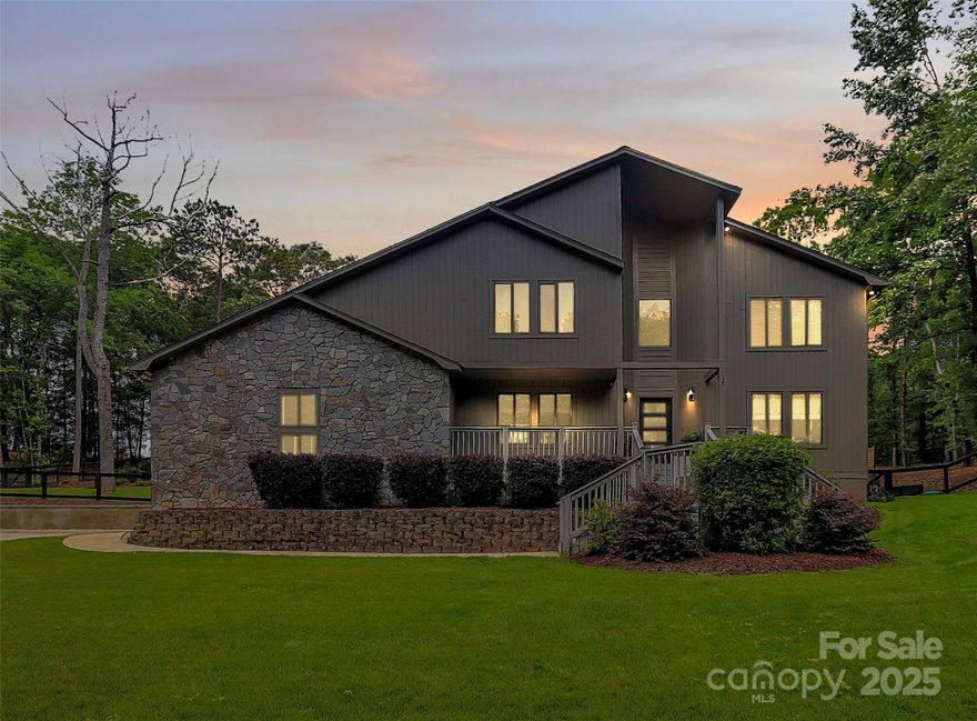 MUST SEE this serene, updated contemporary retreat on over 2 wooded acres in the equestrian community of Black Horse Run. Professionally landscaped backyard, features include a custom designed retaining wall that adds both function and modern appeal to the expanded backyard, enclosed EZ Breeze-style porch, new patio, irrigation system all on a private oversized lot. Inside, enjoy an open floor plan with a 2-story great room, wet bar, granite kitchen with wine fridge and custom cabinetry. Bathrooms have been professionally designed and installed. Updates include: new exterior doors, designer lighting, custom stair rail, ELFA closets, custom window shades, and new microwave and dishwasher. Primary suite upstairs includes a private balcony. Upstairs HVAC 2019; downstairs unit and furnace 2023. Septic serviced 2024. Enjoy direct access to community horse trails and barn infrastructure. Black Horse Run offers peaceful country living with easy access to Charlotte and surrounding counties.