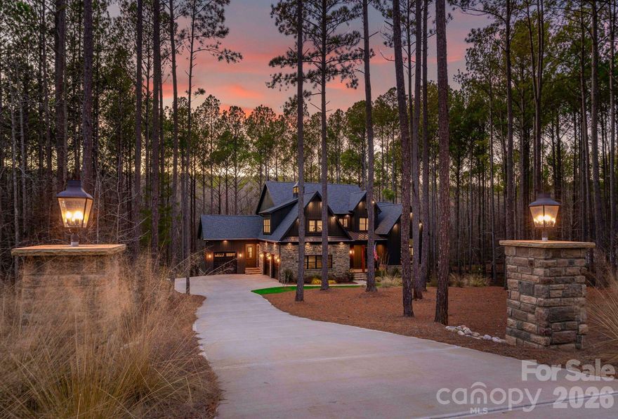 Custom luxury meets modern living in this exceptional estate set on a private, wooded lot close to an acre! This home offers over 4,300 sq ft of finished living space plus a huge walkout daylight basement you can design and customize to fit your needs. The open floor plan features white oak hardwood floors throughout, tons of natural light and the perfect flow for entertaining. The gourmet kitchen enhanced with quartz counters, Monogram appliances including two dishwashers, gas cooktop, pot filler and beverage fridge. The great room includes a coffered ceiling, linear gas fireplace, and stacking sliding doors that open to a huge screened porch that feels cozy and overlooks spectacular wooded views. The main-level primary suite offers a spa-style bath with heated floors, oversized walk-in shower, and a custom walk-through closet with laundry access. Two dedicated home offices are also located on the main level. Upstairs includes an ensuite bedroom, additional bedrooms with shared bath access, and a spacious bonus room. The walkout basement provides excellent potential for future living space with a separate entrance, plumbing in place, and a large workshop or studio area. It also features a hidden vault room to store valuables and serve as a panic room. Additional highlights include a fully automated smart home system that controls all shades, lights and security, oversized garages, a whole house generator and access to community amenities including pool, clubhouse, pickleball courts, trails, and river access. Convenient location with low county taxes and easy access to shopping, dining, and Charlotte.