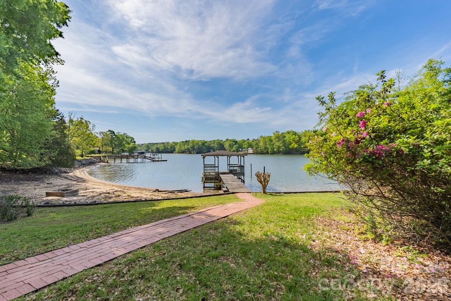 The view you have been looking for can be found at 213 Price Place Lane with 1.4 acres of lakefront living!  This one-owner home is ready to welcome new owners and is a blank slate waiting for you to make it your own.  The main floor is home to the kitchen, dining room, family room with fireplace, and primary bedroom with private bath.  Upstairs features two additional bedrooms and a full bath.  A detached garage offers space for vehicles or storage.  Enjoy your morning coffee on the screened porch or relax on the rocking chair front porch as you enjoy the highlight of this property – the incredible water views!  Spend those warm spring and summer days enjoying all the water activities that draw you to the lake.  A permitted dock and covered cabana are included with this property – and with some updating - can be a fabulous spot to fish, sunbathe, enjoy the water, or whatever you choose.  You need to come see the potential this one has to be your next home!