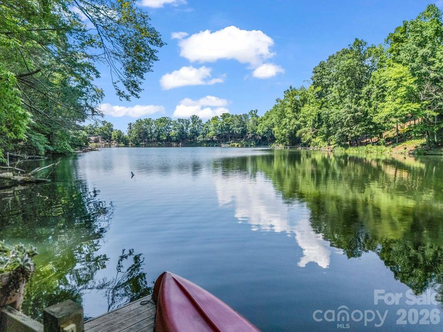 Scenic views of Bald Mountain Lake and mountains from this charming lakefront cottage w its own private dock. Beautifully remodeled kitchen! New cabinets offer abundant & efficient storage with front-load washer and dryer neatly tucked inside the cabinets. Granite counters & a breakfast bar/island provide tons of workspace. Open concept great room with a vaulted ceiling, stunning stone wood-burning fireplace, and floor-to-ceiling windows bring in the natural surroundings and views. Two cozy bedrooms and two full bathrooms on the main level. An additional guest room and loft area overlook the great room. Expansive rear deck and a hot tub sits on the side deck. The unfinished basement has another washer and dryer, separate storage room, and potential for add'l living space. Easy pathway down to your own private lakefront dock + access to Rumbling Bald extensive amenities, including a private beach & Lake Lure. Priced to allow for any desired updates to suit your unique style.