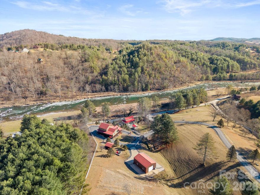 Privately gated and overlooking the North Fork New River, this fully furnished custom home delivers luxury living in a peaceful, scenic setting. This home offers 3 bedrooms (4 sleeping areas) and 4.5 baths with an open-concept layout designed for both everyday living and entertaining, seamlessly connecting the kitchen, dining, and living spaces with abundant natural light and expansive views. A secluded primary suite is set apart for added privacy and features its own laundry area, oversized windows, a jacuzzi soaking tub, and a walk-in steam shower. Two additional bedrooms are located on the main level. Outdoor amenities elevate the property with a custom firepit, gazebo, and hot tub, creating ideal spaces to relax and entertain. A heated barn- complete with ATVs, canoes, and additional recreational equipment, adds exceptional value for outdoor enthusiasts. The home also includes a two-car tiled attached garage. There is a 3-bedroom permit while offering 4 actual bedrooms with windows and closets + an additional office space. An easy circle driveway provides ample parking for guests. Never rented or permanently occupied, this meticulously maintained custom home remains in pristine condition and offers a rare opportunity to enjoy refined living surrounded by the natural beauty of the North Fork New River!