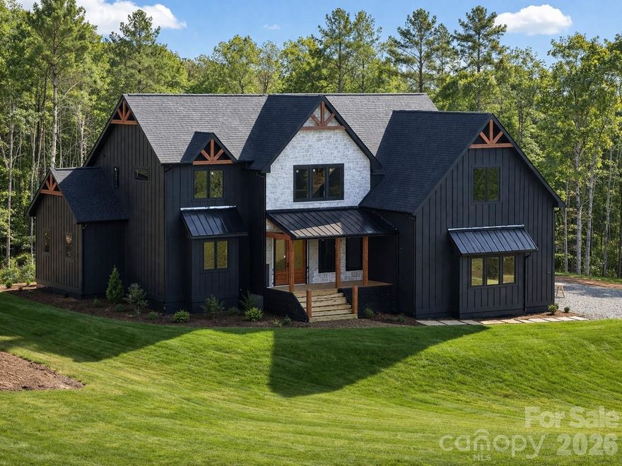 AVAILABLE MAY 2026 | NEW CONSTRUCTION

Ideally positioned just minutes from the charm, dining, and everyday conveniences of downtown Weaverville, and only 15 minutes from the cultural energy of downtown Asheville, this exceptional craftsman-inspired luxury mountain home is offered by the preferred builder in Garrison Hills, with a long-standing presence and commitment to the community. Thoughtfully designed, this residence offers refined craftsmanship, timeless architecture, and generous private outdoor living spaces, all with convenient access to I-26.

The home welcomes you with an open foyer, a classic staircase, and a dedicated main-level office with glass doors. The great room makes a dramatic impression with soaring 20-foot vaulted ceilings, oversized windows, and a stunning floor-to-ceiling stone gas fireplace. With 10-foot ceilings throughout the main living areas and 8-foot custom doors, the layout balances open living with well-defined, comfortable spaces.

Expansive sliding doors off the great room open to a screened rear porch with a wood-burning fireplace, creating a seamless indoor-outdoor living experience ideal for entertaining or quiet mountain evenings.

The chef’s kitchen is both elegant and functional, featuring rich natural gray wood-tone cabinetry, quartzite countertops, Thermador appliances, premium finishes, and a well-appointed butler’s pantry.

The main-level primary suite serves as a private retreat with glass door opening to exterior screened porch, dual walk-in closets, and a spa-inspired bath featuring a freestanding soaking tub and a walk-in shower clad in dramatic polished porcelain tile in warm brown tones.

Upstairs, a spacious sunlit loft offers the perfect setting for a cozy reading area or an open secondary office overlooking the great room. The upper level is complemented by a large bonus room—ideal for a playroom, workout space, or media room—and two generously sized ensuite bedrooms, each with luxurious private baths providing comfort and privacy for family or guests.

The thoughtfully designed garage with 13.5’ ft ceilings accommodates a flexible 2+1 configuration, for a three-car layout or an oversized two-car garage with extensive storage. Situated in the desirable luxury neighborhood of Garrison Hills, this private setting combines peaceful mountain living with everyday convenience—just minutes to I-26, grocery stores, shopping, dining, and the planned AdventHealth hospital.