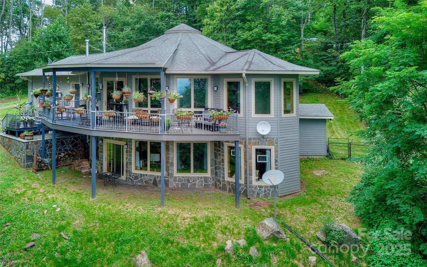 Escape to Arrowhead Retreat, a breathtaking 4-bedroom, 2-bath mountaintop pavilion-style home on 2.57 high-altitude acres, offering unrivaled panoramic views of misty Blue Ridge Mountains and lush valleys. Nestled just off US Hwy. 19-E between Burnsville and Spruce Pine, NC, this rare gem combines serene privacy with convenient access to the Penland School of Crafts, and vibrant local communities—10 minutes to Spruce Pine, 15 to Burnsville, 50 to Asheville, and 2 hours from Charlotte.
UNPARALLELED VIEWS & EXCLUSIVITY: Revel in an 89-mile view-shed, where sunlight and cloud shadows dance across ancient peaks, rivaling the finest Blue Ridge Parkway overlooks. Known as “Elo Gadusi Tsudisdaya” (The Land of Unending Mountains) by the Cherokees, this property offers a front-row seat to nature’s grandeur. With zoning-free land and light deed protections, additional adjoining lots are available to expand your legacy or own the entire mountaintop.
ARCHITECTURAL MASTERY & SUSTAINABILITY: Built in 2011 by master craftsman J.R. Simmons, this Deltec®-designed home is engineered for strength and efficiency, using Southern Georgia Yellow Pine and BluWood® framing to resist rot, mold, and termites. Featuring Marvin® double-pane impact windows, James Hardie® siding, and a hurricane-rated roof, it’s built to withstand extreme weather. A 5.7KW solar system by Sundance Power Systems, a Generac® 18KW propane generator, and a 1,500-gallon rainwater collection system with advanced purification ensure sustainable living. Superior Walls® precast concrete foundations and Fiberon® composite decking enhance durability and eco-friendliness.
INTERIOR ELEGANCE: Step into an open floor plan with vaulted pickled-pine ceilings, reclaimed antique pine floors, and oversized windows framing ever-changing vistas. The craftsman-style kitchen boasts GE Profile™ appliances, quartz countertops, a curved island, and custom maple cabinetry by local artisan John Pendley. A Bari® soapstone rotating fireplace, meeting 2020 EPA standards, adds warmth and sophistication. The helical staircase, with rope-inlaid handrails and ornate ironwork, leads to a light-filled upper landing. The master suite features dual vanities, a jetted tub, and a walk-in closet, while the lower level offers an entertainment area with a kegerator bar, Bark House® accents, and a Jotul® wood stove.
LIFESTYLE & AMENITIES: Enjoy radiant floor heating, ductless hybrid heat/AC, and a whole-house dehumidifier. The lower-level media room, guest bath with a stand-up urinal, and walk-out gravel area elevate entertainment. A scullery/pantry, laundry room, and supersized garage with workshop potential add functionality. Native wildlife and a diverse ecosystem thrive in this National Park-like setting, perfect for families or retreats.
YOUR MOUNTAIN LEGACY AWAITS: At 1024 Arrowhead Ridge Road, every drive is scenic, every sunset unforgettable. Leave stress behind and embrace a lifestyle where altitude uplifts your attitude. This is mountain living at its finest—secure, sustainable, and exclusive. Schedule your private tour today to claim your piece of the Eternal Mountains!