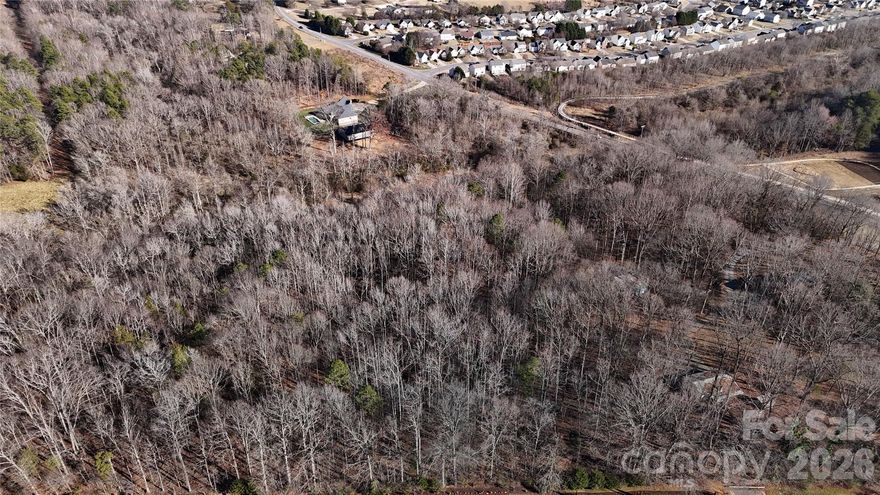 Sixteen (16) private, wooded acres with a bordering stream, barn, garden all just minutes from the best schools Mooresville is known for. Previous equestrian use