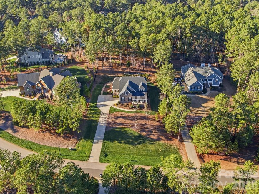 This is one of the most stunning and meticulously maintained homes you'll find! Gorgeous wide plank floors throughout, beautiful light fixtures and lots of trim work. Natural light fills every room! The primary suite is located on the main floor and features a spa-like bathroom with a huge walk-in shower. An additional bedroom and full bath on the main floor is ideal for guests or office space. A spacious dining room. Impressive kitchen with a spacious island, gas cooktop, farmhouse sink, quartz counters and open flow into the great room with stacked stone fireplace. A laundry room you can enjoy with cabinets, stylish tile floors & counterspace to fold.  Upstairs another bedroom, full bath, a loft and storage! Three season room is perfect for morning coffee or an evening glass of wine complete with vinyl windows that you can open or close to enjoy the porch year round. Step outside to the flat patio, perfect for grilling and enjoying an afternoon barbecue. Beyond the patio, a stone path leads to a large upper flat yard area with endless potential for a future pool, fire pit, playground, garden, or additional outdoor living space. Additional upgrades include an encapsulated crawlspace with a dehumidifier, a whole-house generator, a whole-house surge protector, and a tankless water heater plus extended driveway apron for multiple car parking and turnaround space.  Riverchase Estates offers a luxury lifestyle with lower Lancaster County taxes and resort-style amenities including Catawba River access, clubhouse, fitness center, pool, sports courts, playground, trails, and a 500-acre nature preserve. The area continues to see tremendous growth with shopping, dining, grocery stores, and conveniences including Costco and Target all within about 15 minutes.