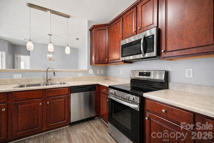 NEW STAINLESS STEEL APPLIANCE PACKAGE installed 4/18/26. Unbeatable value and versatility in Cornelius! This spacious Alexander Chase condo is a rare find, offering two large bedrooms PLUS a dedicated flex room- the perfect "3rd bedroom" option, home office, or hobby space.  Enjoy direct access to the McDowell Creek Greenway and walk to the premier dining, shopping, and cinema at Birkdale Village! You are also just five minutes from the new Atrium Health medical center and the waterfront at Ramsey Creek Park. The interior features an airy, open layout with 9-foot ceilings and durable vinyl plank flooring throughout- absolutely no carpet to maintain! The oversized primary suite serves as a true retreat, flooded with natural light from windows on two sides. A large kitchen w/new faucet offers a long breakfast bar and ample cabinetry, ready for your meal creations. Retreat to your private balcony, which includes a convenient storage closet for extra gear. For a truly seamless move, the never-used refrigerator, washer, and dryer are all included! Residents enjoy amenities including a pool, clubhouse and fitness center. The building's dual-entry layout keeps through-traffic minimal, offering a quieter, more private day-to-day experience. HOA dues cover water and trash, parking space #56 is assigned, and a one-year American Home Shield warranty (HVAC + major appliances) is included for peace of mind. Owner-occupants only for the first two years; rental cap has been reached with a waitlist in place. Up to two pets welcome.