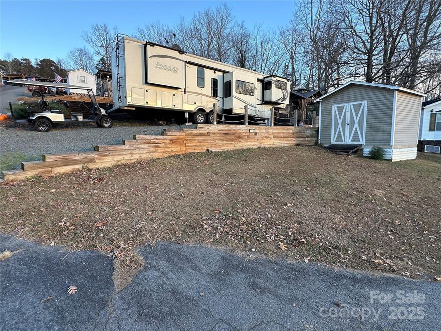 Bring your camper and enjoy lake life on this deeded lot located inside the gated waterfront community of Badin Shores Resort at Badin Lake. ** The lot offers plentiful parking, a storage building for all your lake gear, and a shaded gazebo—perfect for relaxing after a day on the water. Explore everything the resort has to offer, including a seasonal swimming pool, putt-putt golf, sandy beach and swim area, fishing pier, stocked catch-and-release fishing pond, clubhouse, boat ramp, waterfront boardwalk, and more. This is a great opportunity to enjoy resort-style living at Badin Lake. Camper seen in pictures can be purchased separately.