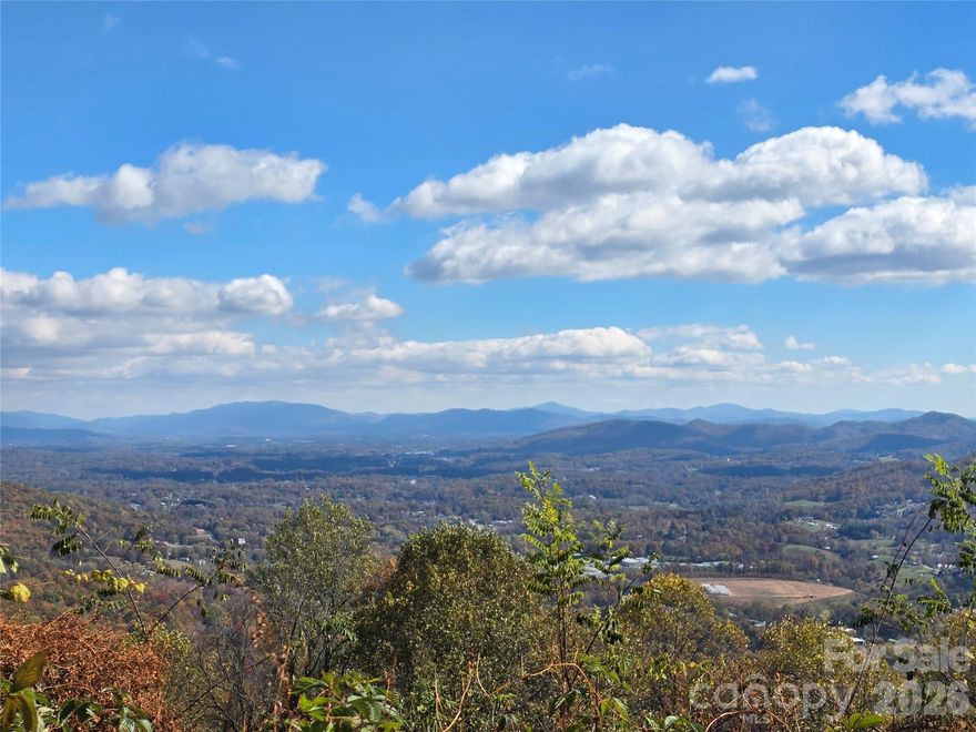 Build the home of your dreams and awaken each morning to breathtaking vistas overlooking Biltmore lands in the distance on this stunning lot with long-range east views in coveted western North Carolina. Enjoy the long-range layered views over Thompson and Pisgah Mountain as the lights twinkle through the night. Situated in the gated *Summit of Asheville* community, this exceptional lot enjoys underground power, fiber-optic internet, and neighborhood access to hiking trails, a seasonal waterfall, and a community garden where neighbors grow, gather, and connect. Paved roads provide effortless access directly to the property. Only 20 minutes from downtown Asheville and 25 from Waynesville, this property balances peaceful mountain seclusion with easy access to urban amenities. Wildlife is abundant and natural beauty surrounds the site. Don't miss your opportunity to see a one of a kind mountain view lot. Schedule a private showing now and secure your slice of mountain paradise with panoramic eastern and southern views!