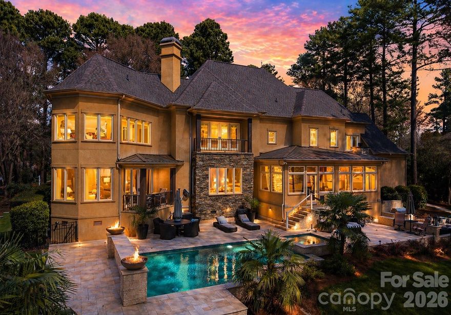 Enjoy breathtaking sunset views over the 3rd hole of Trump National Golf Course from this exceptional estate nestled within The Point. Set on 0.78 acres and offering over 5,700 square feet, this impeccably maintained 4 bedroom, 4.5 bath residence blends timeless elegance with modern comfort, delivering a truly elevated lifestyle.

The outdoor living experience is truly resort caliber, featuring an expansive hardscape designed for both relaxation and entertaining. Enjoy a thoughtfully designed custom hardscape sunken fire pit, outdoor kitchen with grill and bar, and a saltwater pool and spa, creating your own private oasis overlooking the course.

Inside, a grand two story foyer with designer lighting sets an impressive tone. The open concept main level is anchored by a stunning living room with a fireplace, custom built ins, and sweeping views, flowing seamlessly into a sunlit breakfast area and a beautifully appointed chef’s kitchen with granite countertops, designer finishes, and updated hardware.

A serene sunroom with its own fireplace offers a peaceful retreat, while the formal dining room, complete with butler’s pantry access, is ideal for hosting elegant gatherings. The main level primary suite is a true sanctuary, featuring a beautifully mantled fireplace, private access to a covered patio, an expansive custom walk in closet, and a spa inspired bath with a soaking tub and oversized walk in shower.

Upstairs, newly installed carpeting enhances a bright and spacious bonus room overlooking the backyard oasis and golf course. A secondary primary suite with en suite bath and walk in closet provides flexibility for guests or multi generational living. Additional generously sized bedrooms, a shared bath, and a versatile recreation space complete the upper level. Dual laundry rooms on both floors add everyday convenience.

Recent upgrades include a new roof in 2022, an EV charger garage hookup, updated lighting and fixtures, and extensive irrigation and hardscape enhancements.

Residents of The Point enjoy access to premier amenities through a Social Membership, including dining, fitness, tennis, swimming, and a vibrant calendar of community events, delivering a true country club lifestyle. A 12-month leased boat slip in The Point also now comes with the home!

This is luxury living redefined, where every detail has been thoughtfully curated for comfort, style, and effortless entertaining.