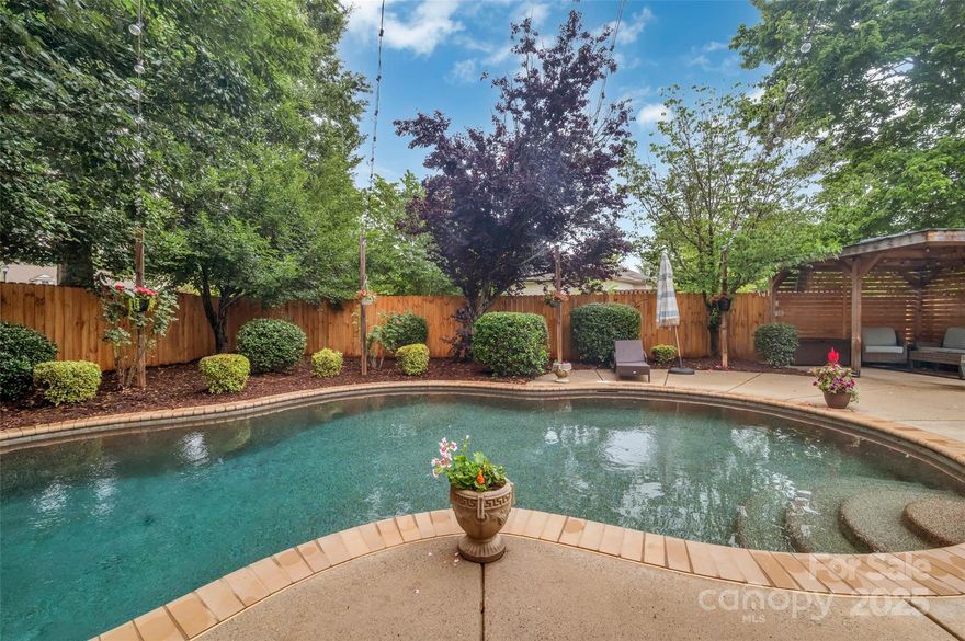 Gorgeous Saltwater Pool & Outdoor Living in Fort Mill, SC!  5 Bedroom plus Office!  Fort Mill Schools!  Beautiful open floor plan with office, dining room, great room, kitchen, dining area, laundry room & half bath on the main floor.  Kitchen has white cabinetry, stainless appliances including French door refrigerator, island without a sink... great for entertaining. Great Room with gas fireplace, pre finished wood floors on the main floor.  Office has French doors for privacy.  Laundry room with cabinetry for storage & includes the washer & dryer.  Upstairs you will find the Primary Bedroom with tray ceiling & board & batten trim wall decor. Walk in Closet & Primary Bath with garden tub & walk in shower.  There are 4 other bedrooms or use bedroom 5 as a Bonus Room, plus a full bath.  The backyard has a covered patio off the dining area, a beautiful saltwater pool with covered gazebo & string lights for a perfect outdoor living space. Enjoy the amenities new pickleball courts, pool, tennis, playground and parks of Fort Mill, SC!