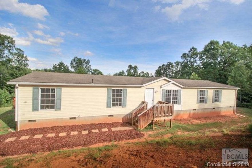 4 Bedrooms, 3 Full Baths, Huge Doublewide home on 3.52 acres.  Energy efficient heat pump for central heat and air conditioning.  New laminate flooring and new carpet!!!  The open floor plan begins with the large front room.  This opens to the large kitchen with Island cooking and breakfast area.  Plenty of cabinet space and a HUGE walk in pantry.  From the kitchen or front room you pass through the open dining area and step down to the sunken living room with incredibly efficient wood stove for backup heating!  Never worry about a heating bill again!  The large master bedroom opens to the master bath with 2, separate sinks, shower and separate, oversize tub.  The master bedroom has a large walk-in closet.  The 2nd bedroom is oversized and has a private entrance to the hall bath.  Bedrooms #3 and #4 are separated by a Jack and Jill bath with 2 sinks.  The 2 car garage and 2 carports are located behind the house.  Used as a workshop and barn, this property is ready to be your new homest